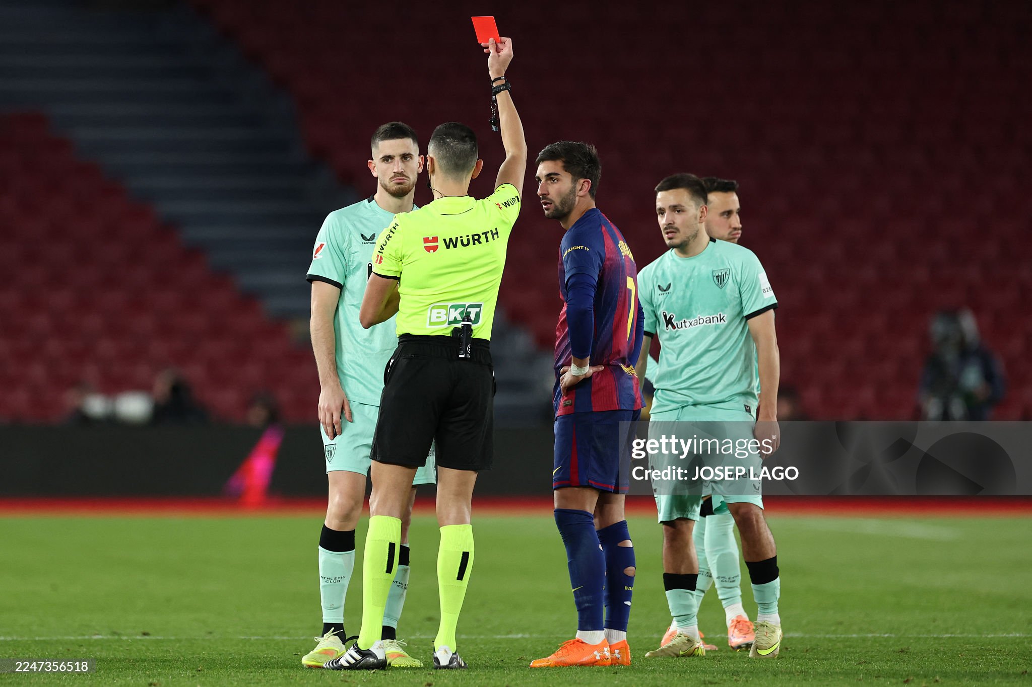 Spanish referee Jose Maria Sanchez presents a red card to Athletic Bilbao's Spanish midfielder #08 Oihan Sancet (L) during the Spanish league football match between FC Barcelona and Athletic Club Bilbao at Camp Nou Stadium in Barcelona on November 22, 2025