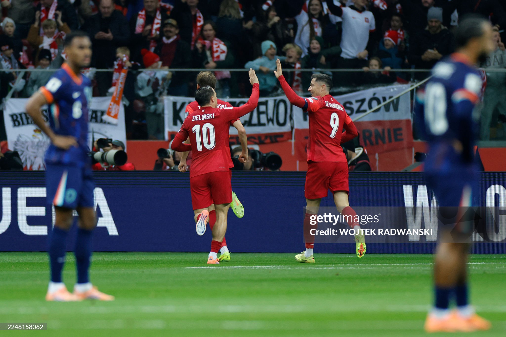 Poland's midfielder #10 Piotr Zielinski (C-L) and Poland's forward #09 Robert Lewandowski (C-R) celebrate after their team scored the opening 1-0 goal during the 1st round - day 9 - Group G World Cup 2026 European Qualifiers football match between Poland and the Netherlands on November 14, 2025 in Warsaw, Poland.